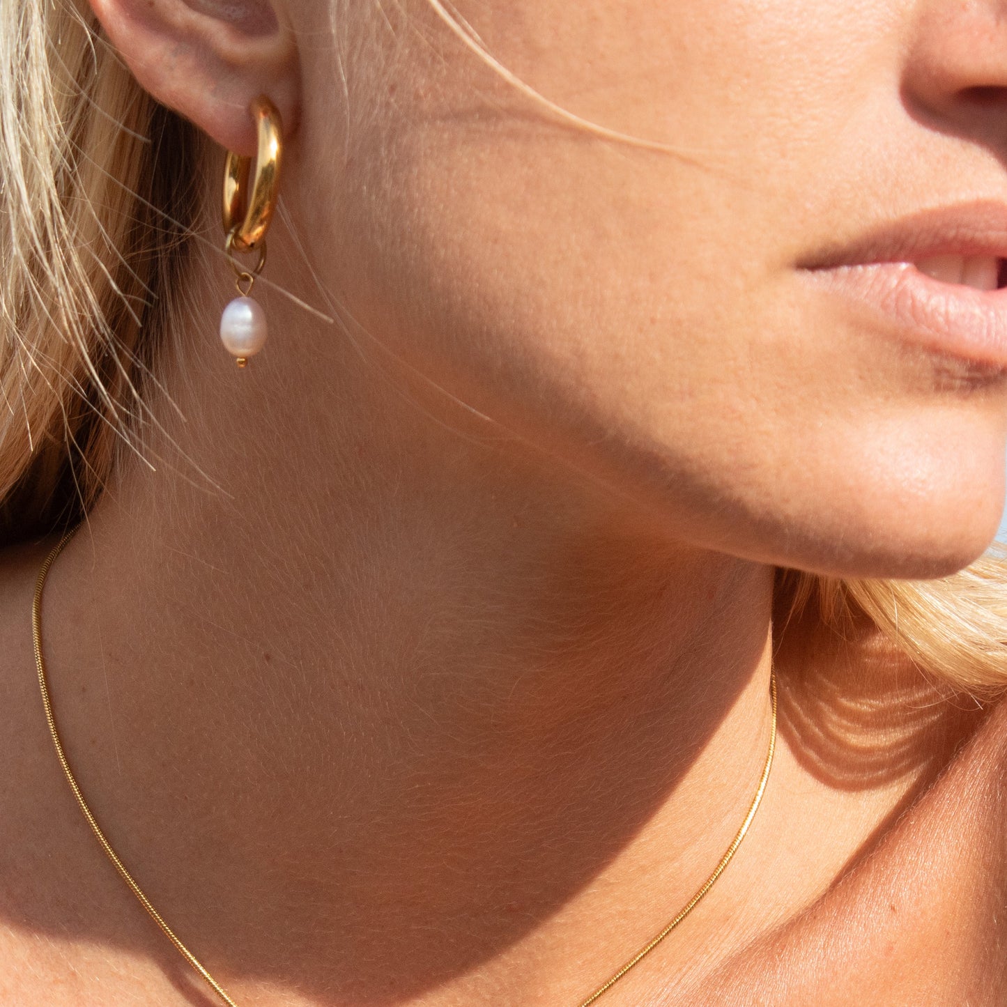 Gold hoop earrings with pearl drop