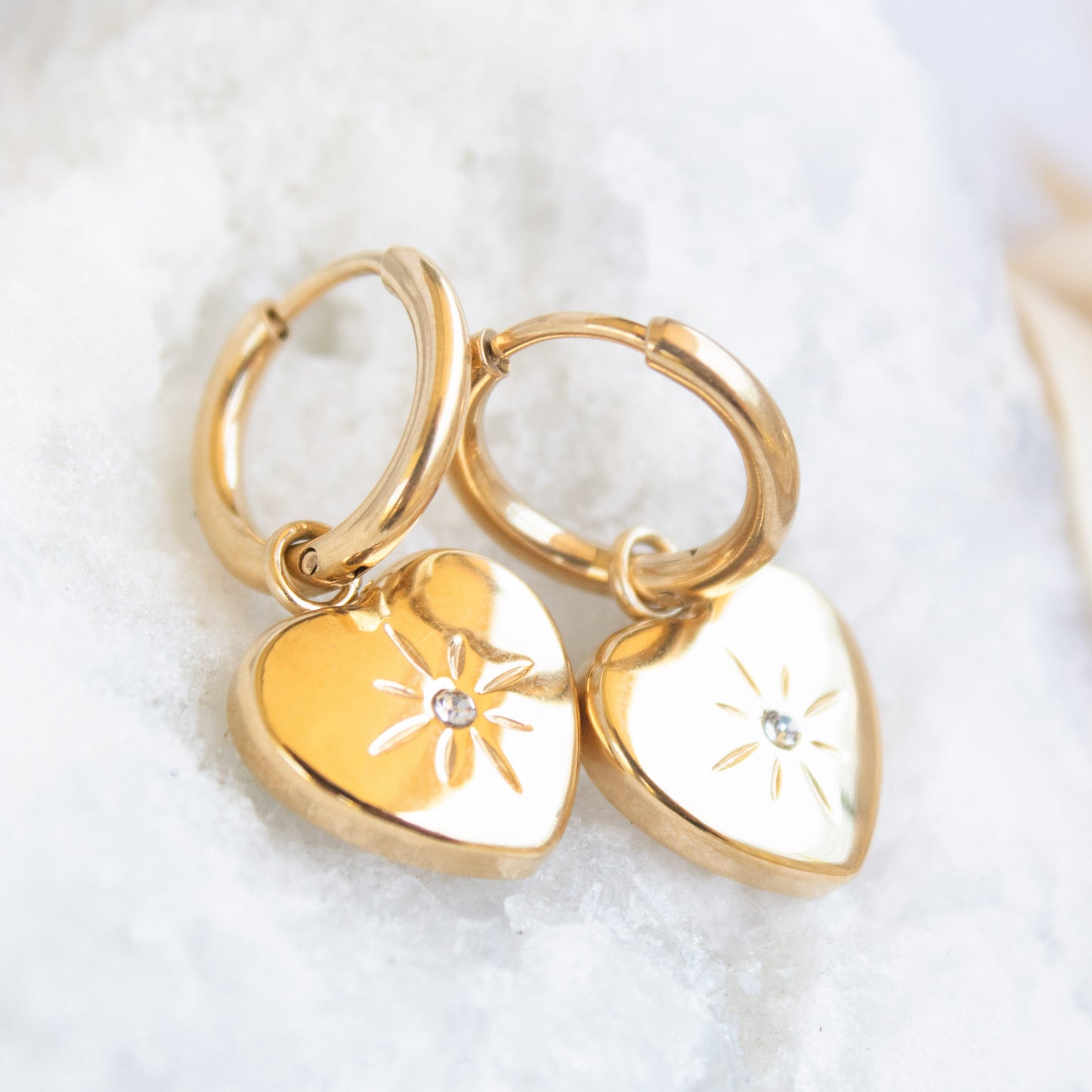 Gold heart hoop earrings with starburst detail