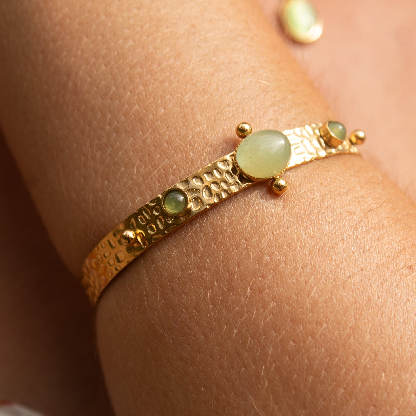 Gold bangle with green stones