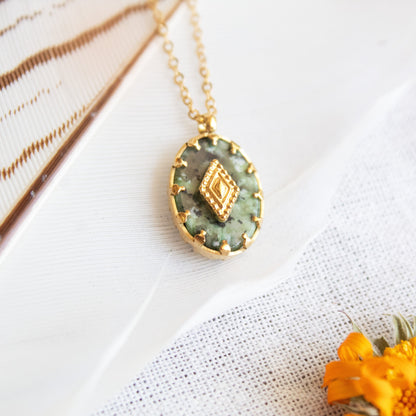 Gold oval pendant necklace with green stone