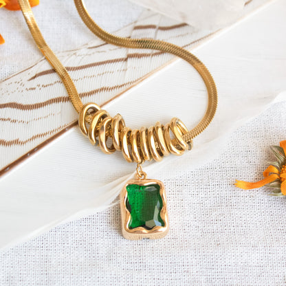Gold snake chain necklace with green gem pendant