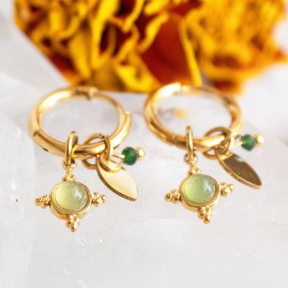 Gold earrings with green stones and leaf charms