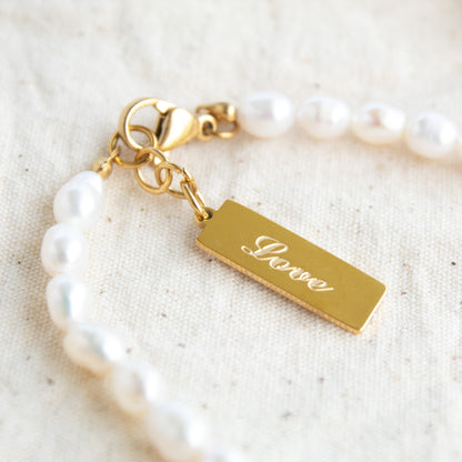 Gold "Love" tag on pearl bracelet