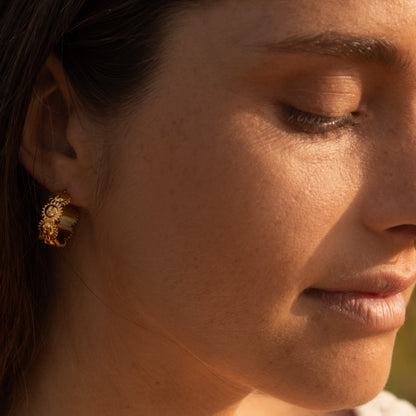 Gold hoop earrings with floral detail