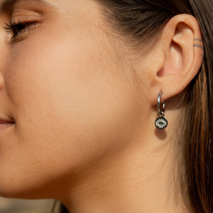 Silver hoop earring with evil eye charm