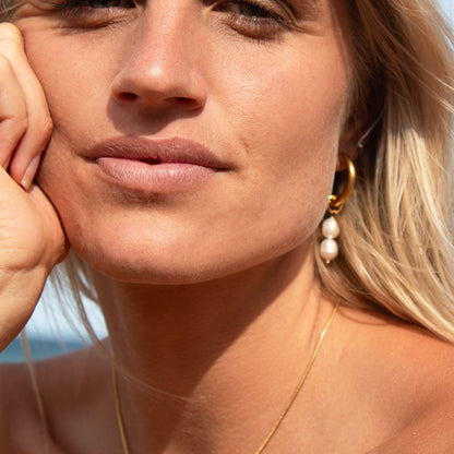 Gold hoop earrings with double pearl drops
