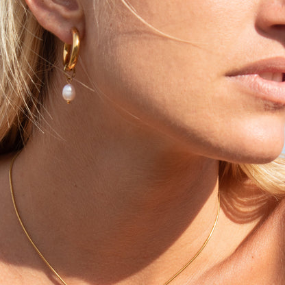 Gold hoop earrings with pearl drop