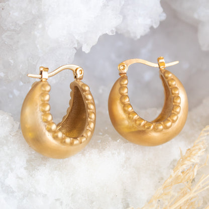 Gold textured hoop earrings with beaded trim