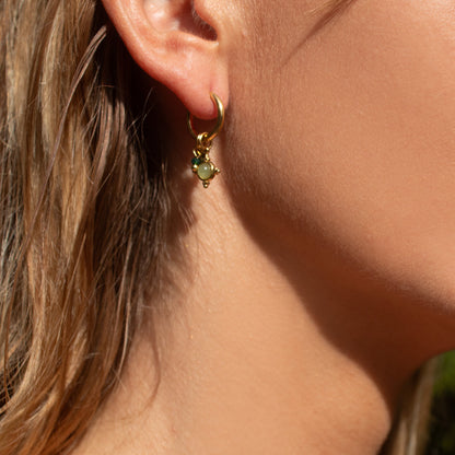 Gold hoop earring with green jewel charm