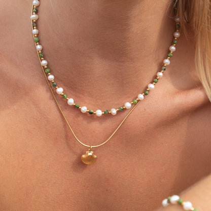 Gold necklace with pearls, green beads, and shell pendant