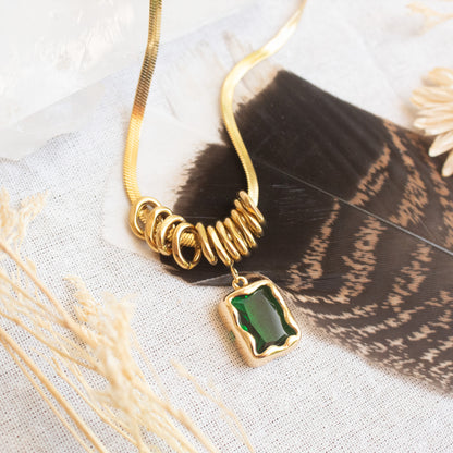 Gold snake chain necklace with green gemstone pendant