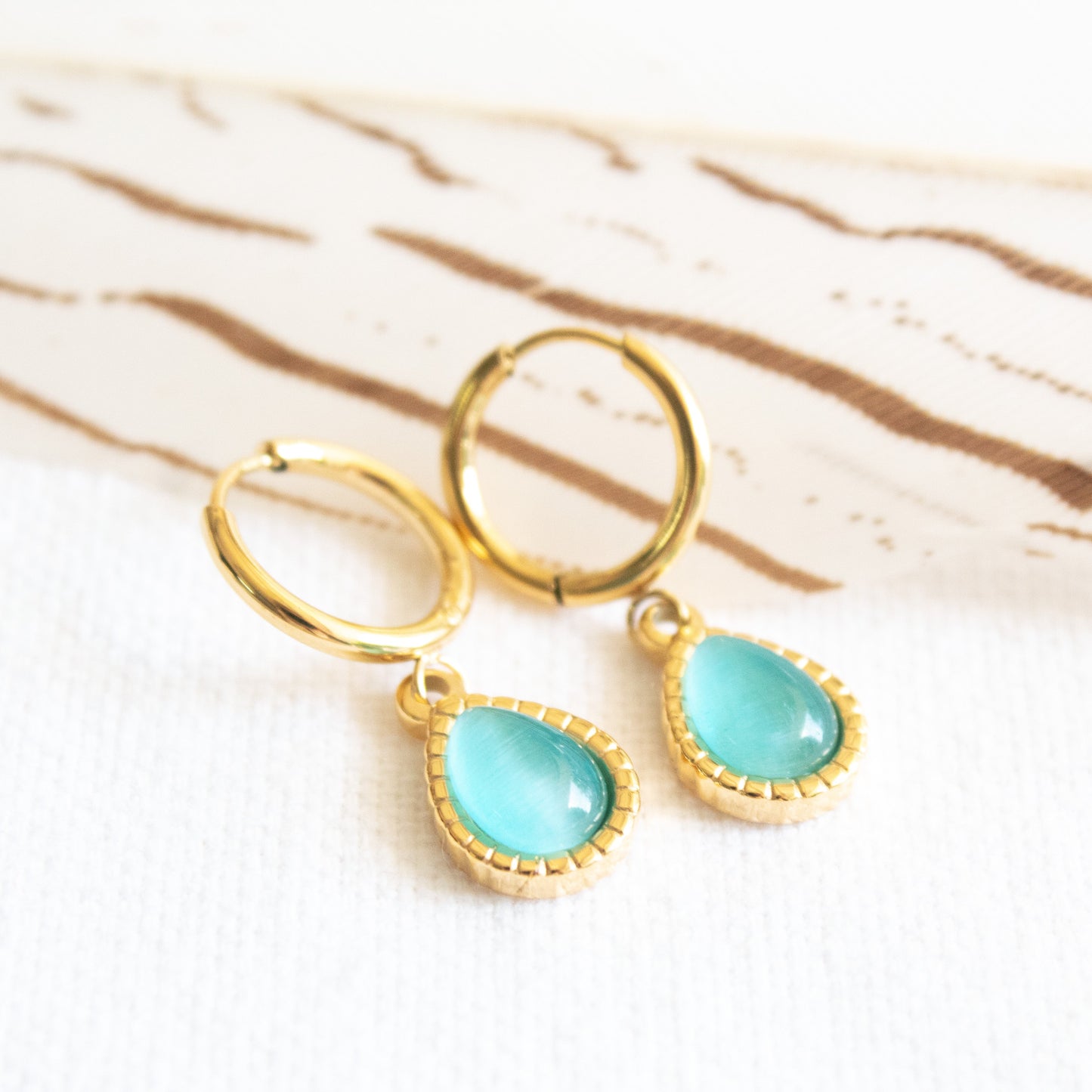 Gold hoop earrings with blue opal droplet charms