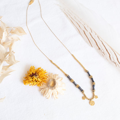 Etheria gold necklace with dark beads & coin charm