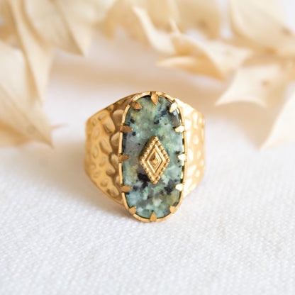 Gold ring with textured band and green stone