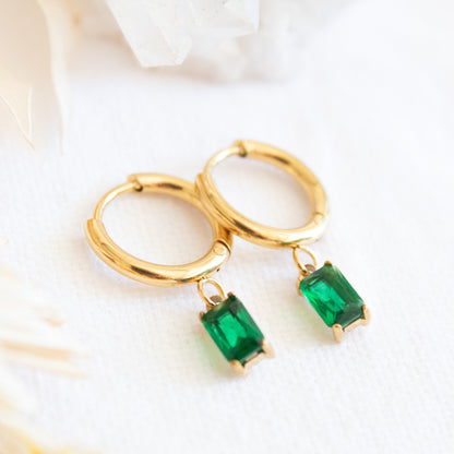 Gold hoop earrings with emerald green drop gems