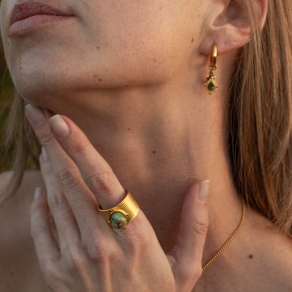 Gold hoop earrings with green gemstone charm