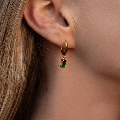 Gold hoop earrings with green emerald charm