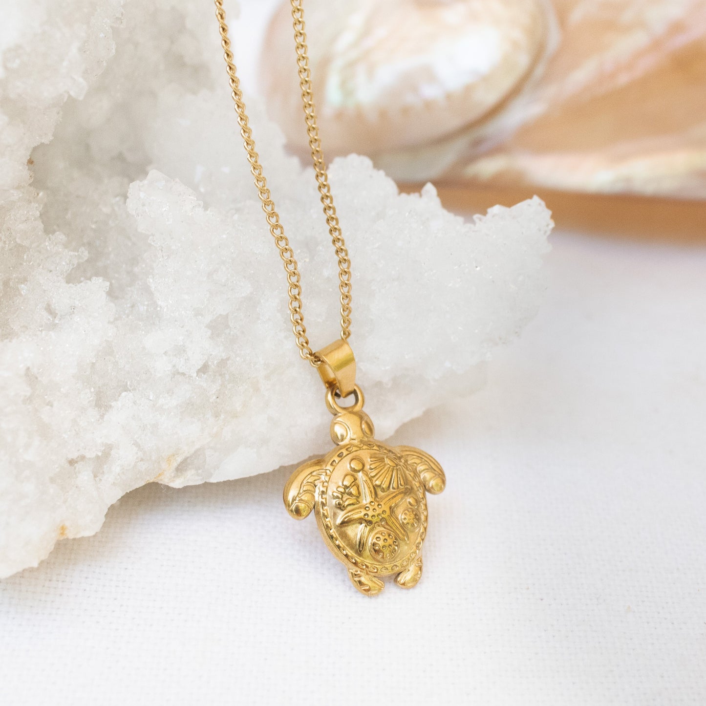 Gold turtle necklace on white