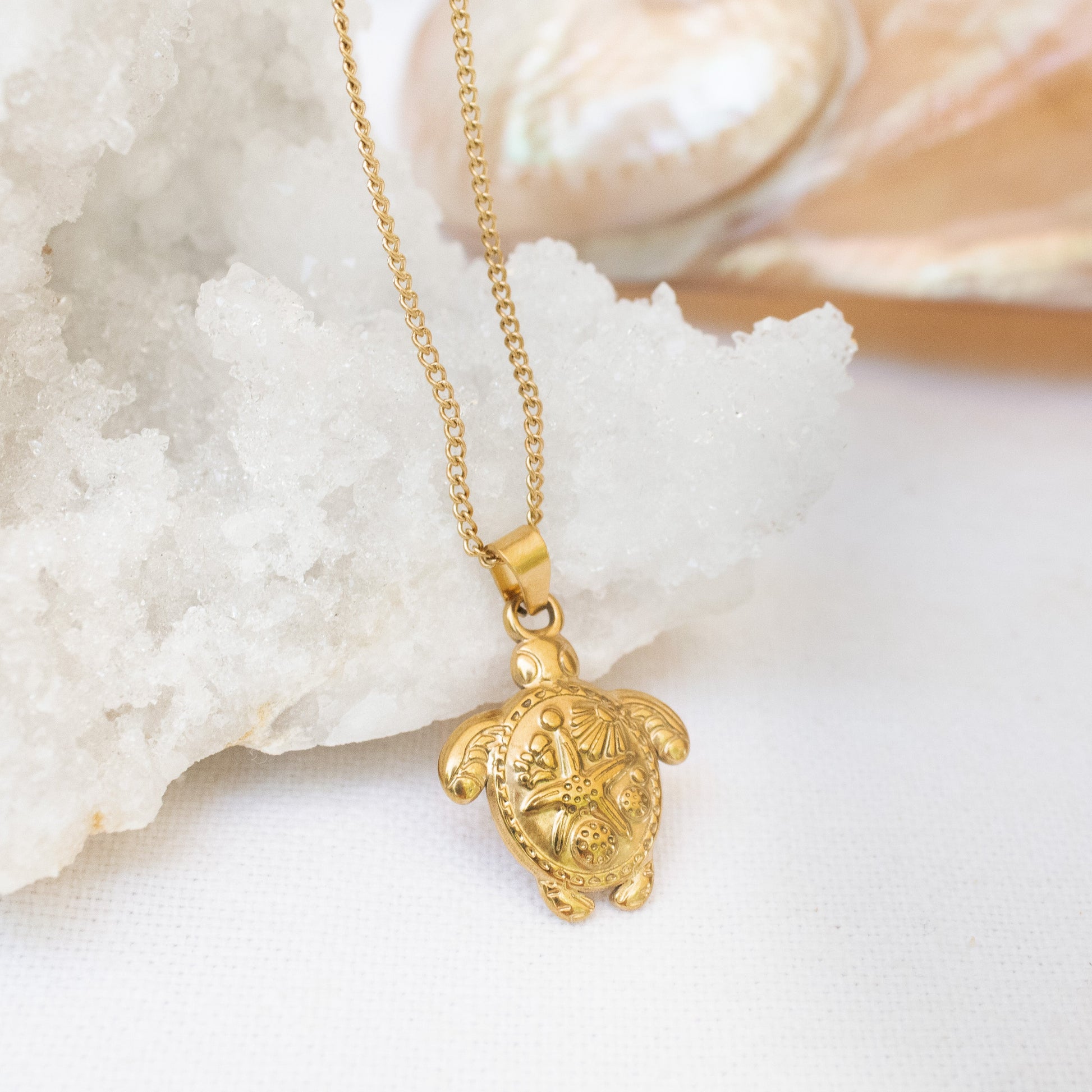 Gold turtle necklace on white