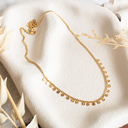 Gold necklace with scattered coin charms
